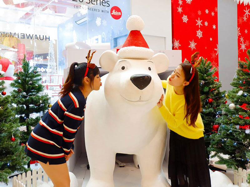 SC ViVo City - Điểm Đến Cuối Tuần Tuyệt Vời Dành Cho Cả Gia Đình 5 Hai cô gái tạo dáng bên tượng gấu trắng đội mũ Noel trong trung tâm thương mại