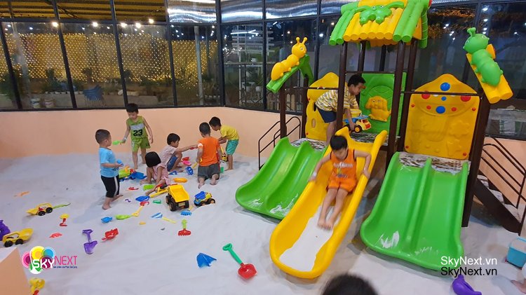 Đầu tư khu vui chơi ở nông thôn 1 Khu vui chơi cát trong nhà với cầu trượt và trẻ em đang chơi