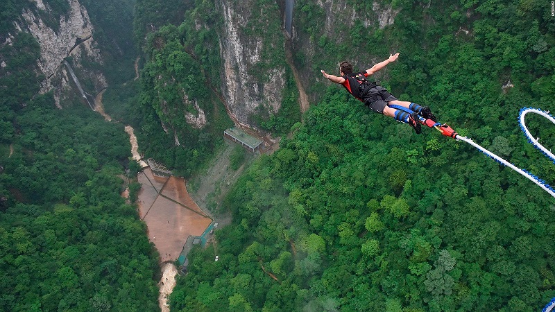 Người chơi bungee trampoline đeo harness và nhảy trên bạt nhún
