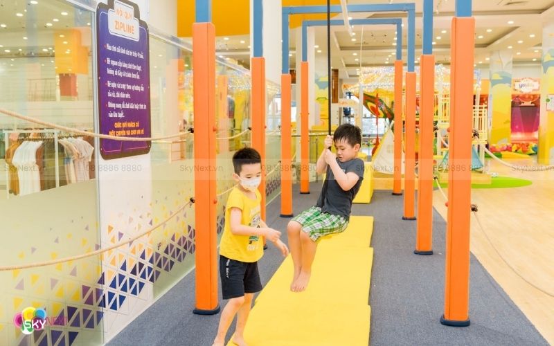 Bé chơi đu dây zipline mini có ghế ngồi dưới sự giám sát của người lớn
