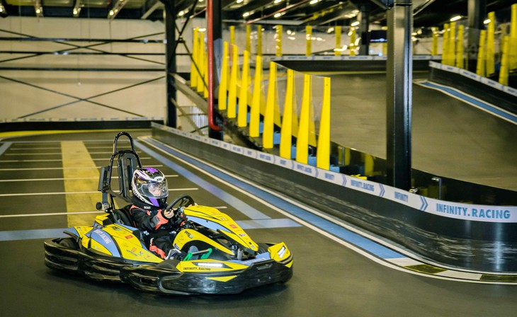 Đua xe go kart gia đình: Cẩm nang trải nghiệm an toàn từ A–Z 1 Gia đình đội mũ bảo hiểm chuẩn bị đua xe go kart tại đường đua indoor