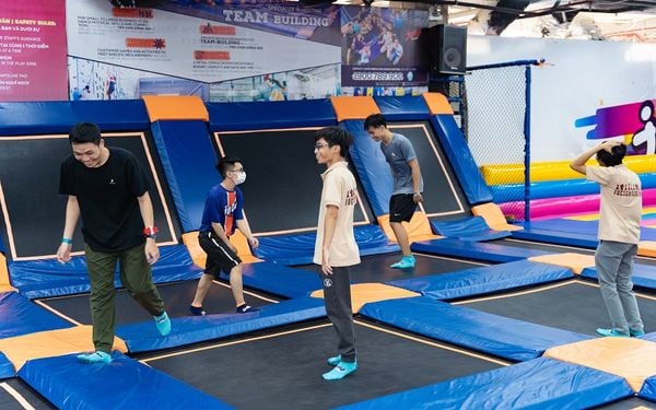 Minh họa phụ huynh kiểm tra 5 yếu tố an toàn trước khi cho trẻ vào khu nhún trampoline